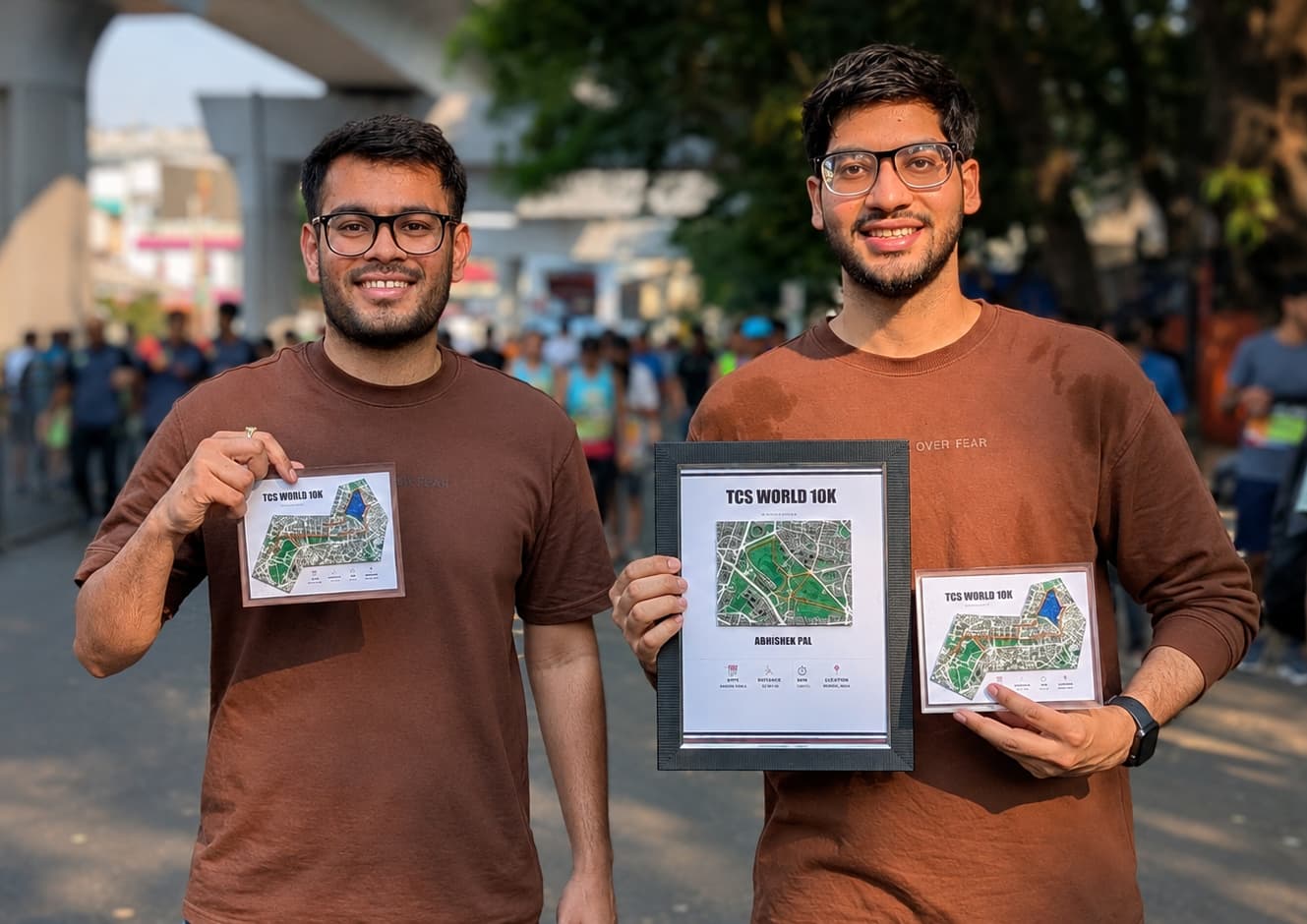 TwoFold team members holding framed TCS World 10K race maps at an outdoor event